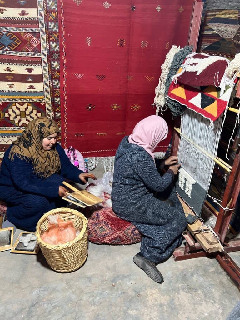 Two Berber women weaving rugs 