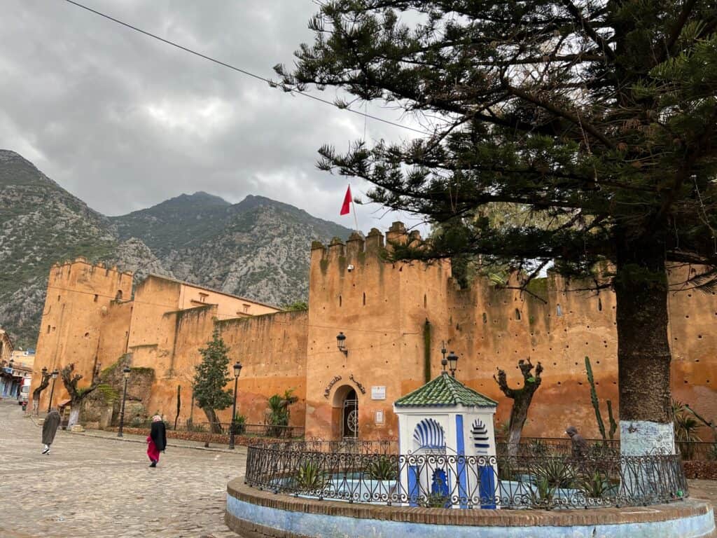 The Kasbah in Chefchaouen with the mountains in the background and grey skies.