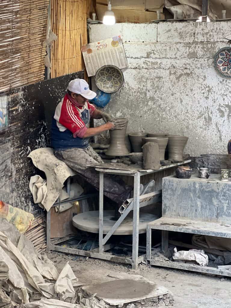 A man using a potters wheel to create pots in Fes. 