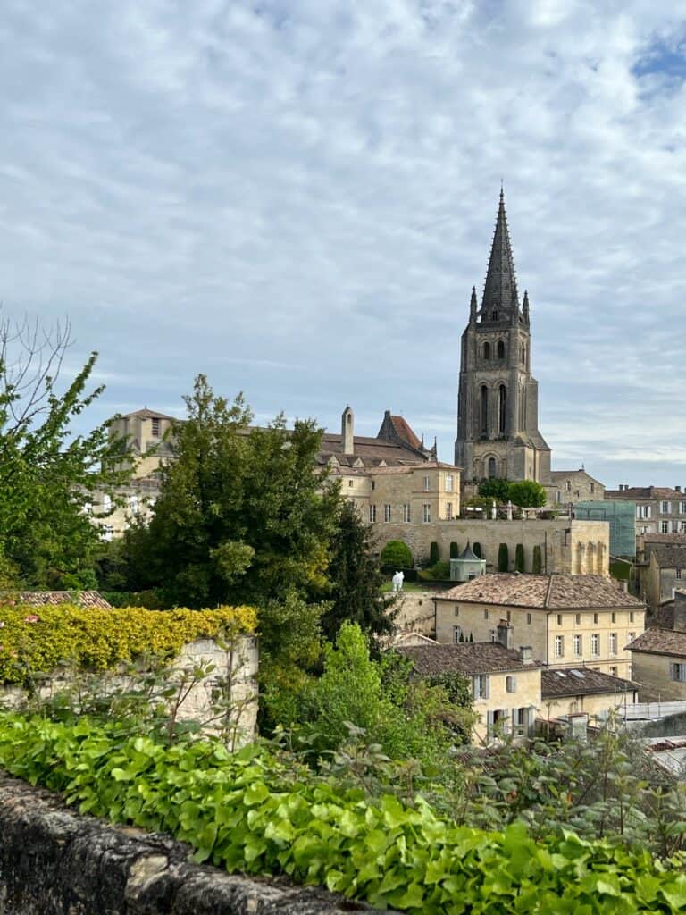 The tall church tower, village buildings and lush greenery of st Emilion