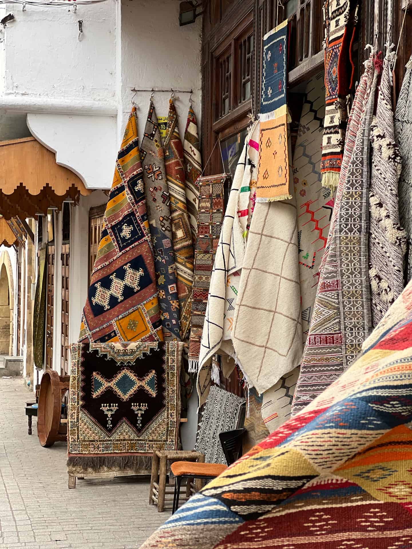 Rugs of different colours in a market stall in Rabat