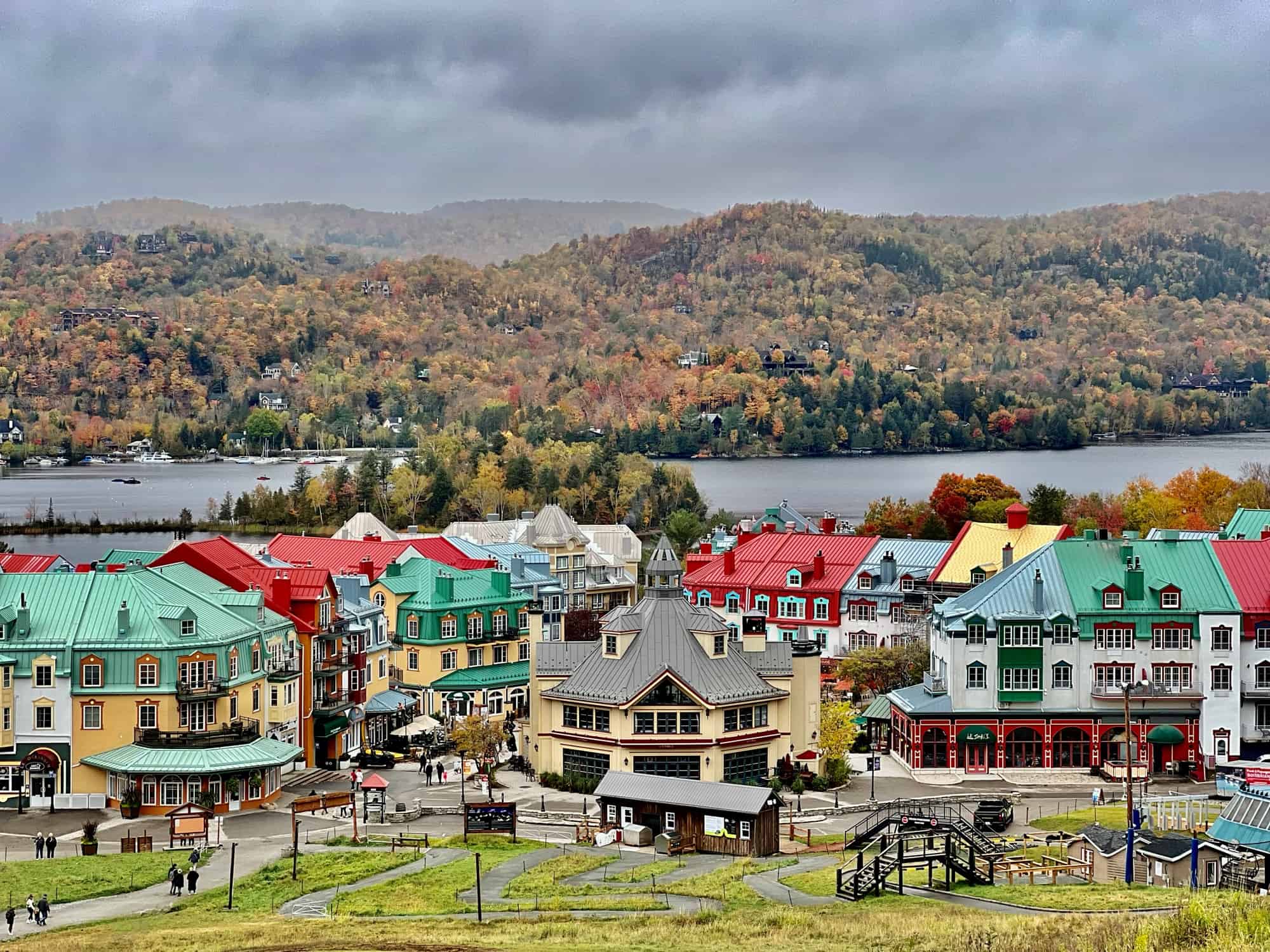 Colourful houses in foreground with lake and fall foliage in the background