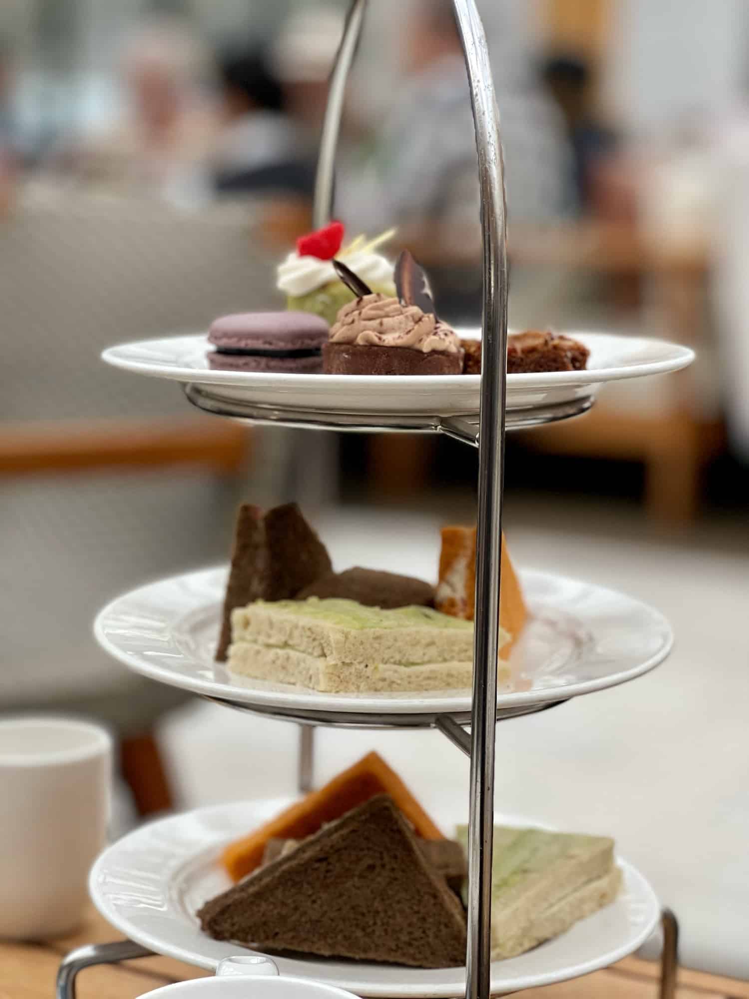 3 tier plate with cakes and sandwiches