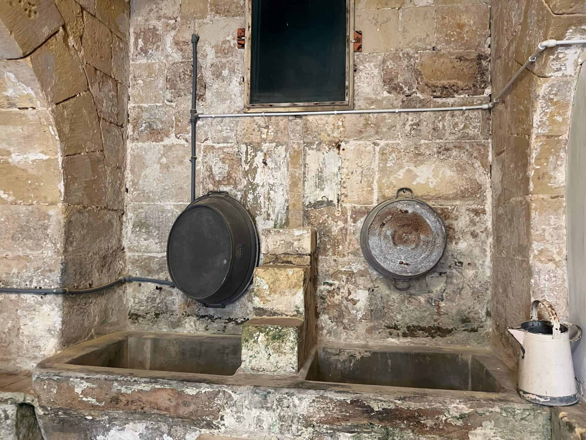 Two sinks and a white jug where the nuns did their laundry