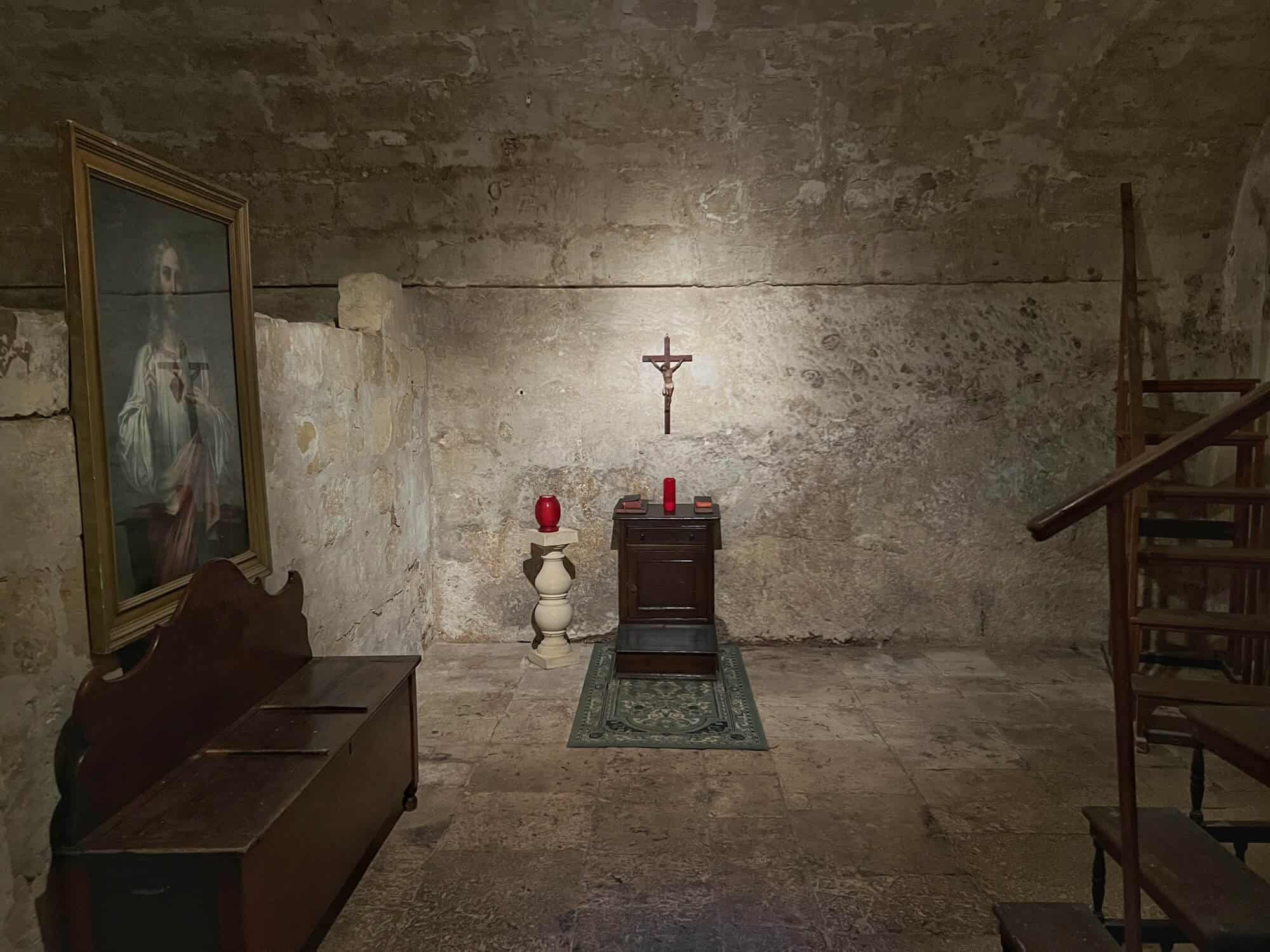 Room with cross on the wall and a chair 