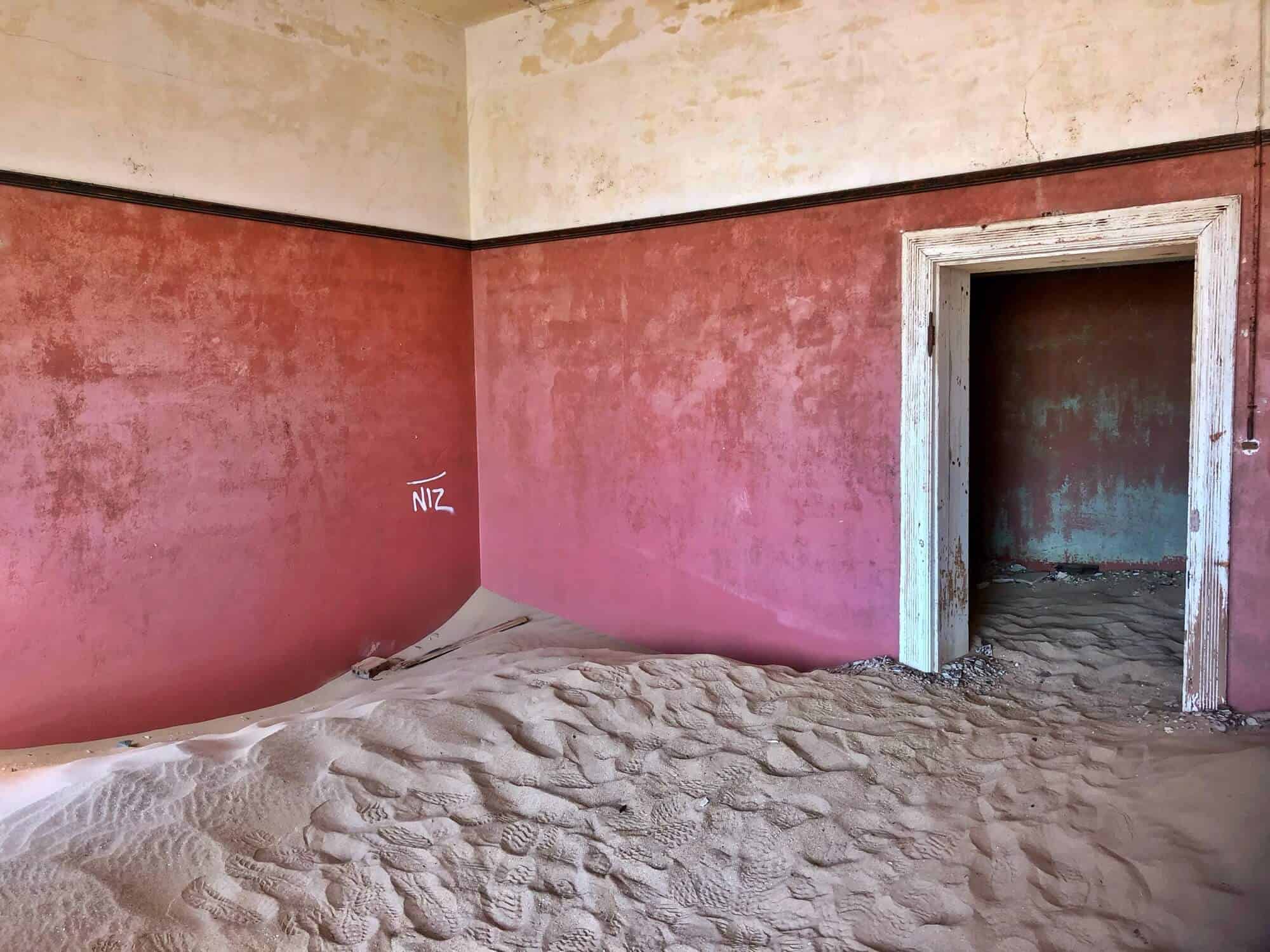 The sand covers the interior floor. Bright pink walls. 