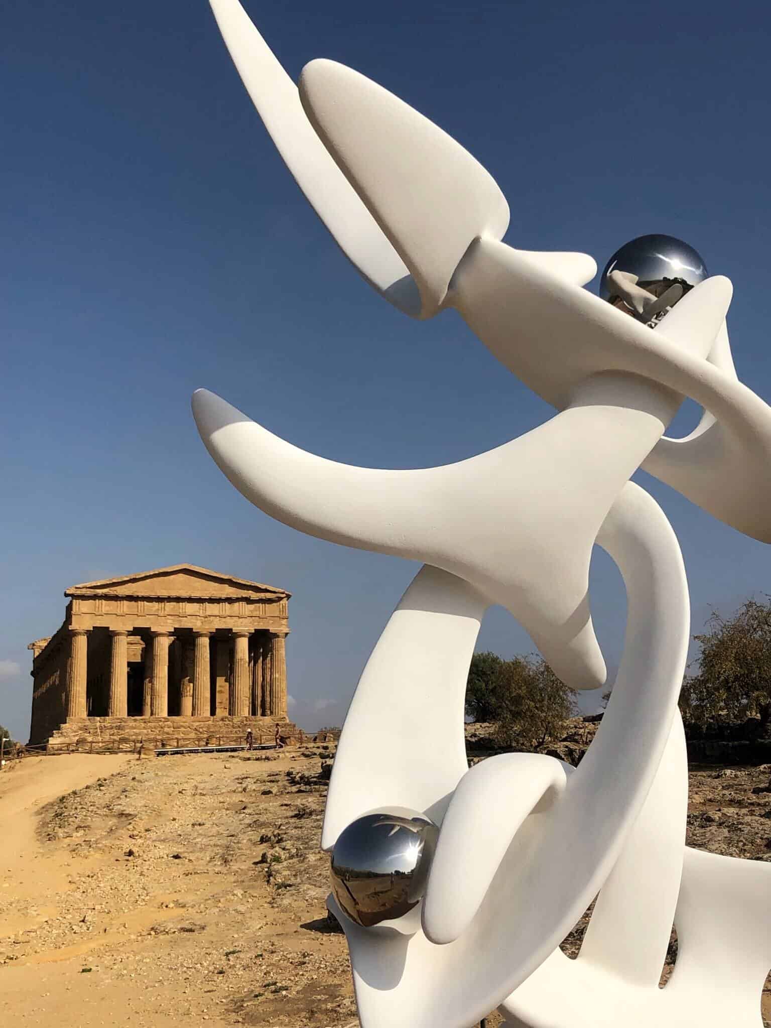 Temple at Valley of the Temples in Agrigento with modern white statue and silver balls