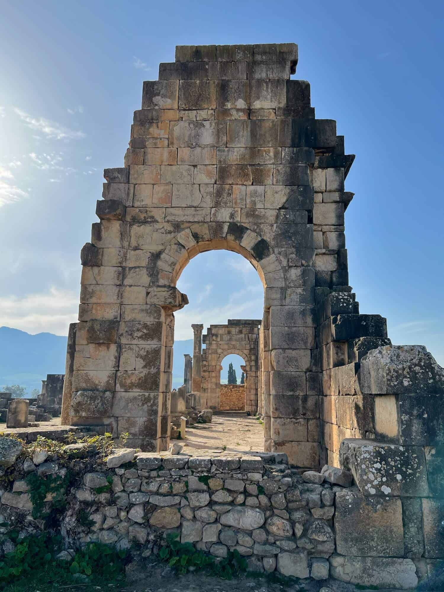 Roman archways under blue sky at Volubilis in Morocco 