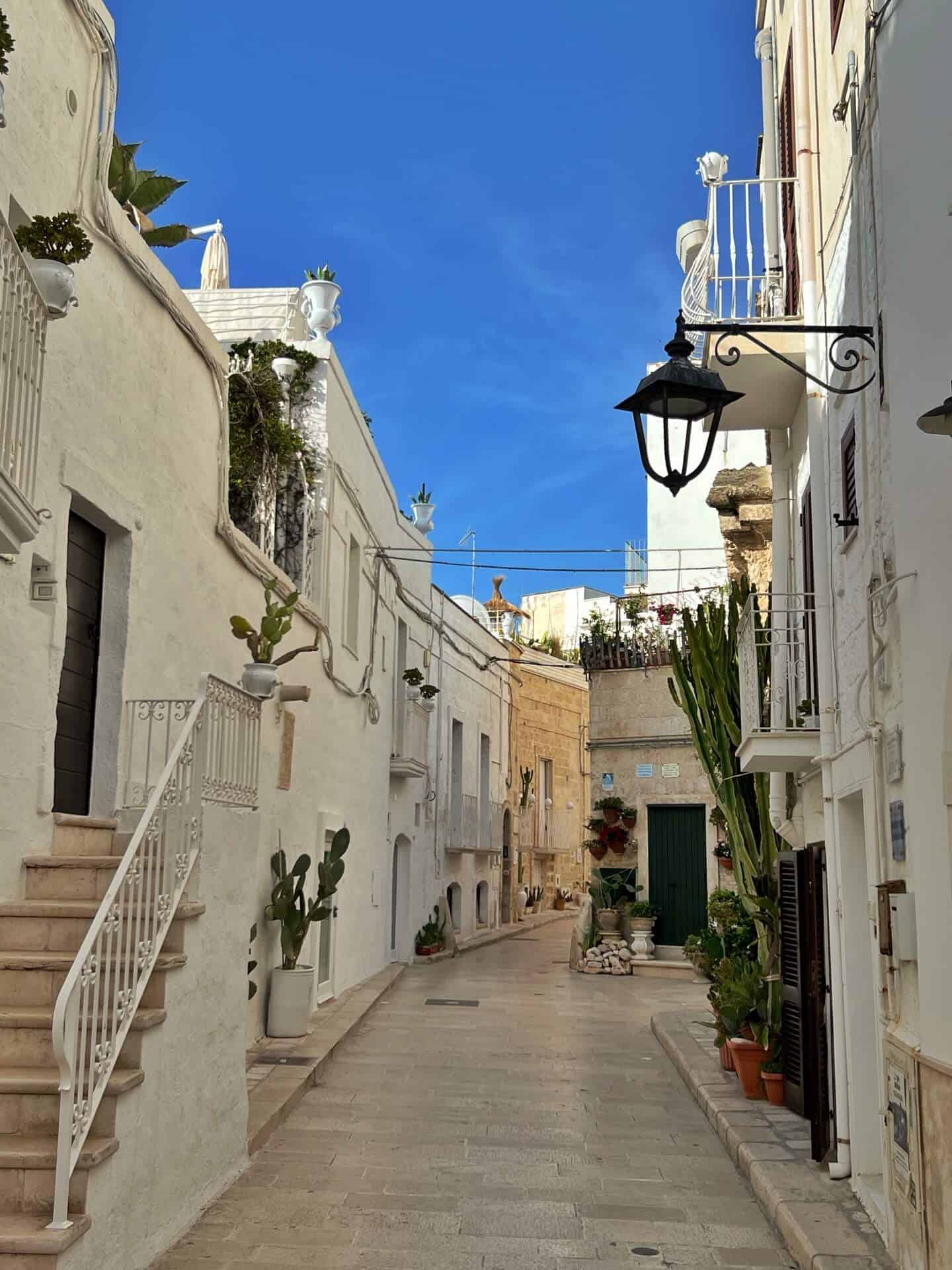 Blue sky against the white houses on an empty street in Monopoli 