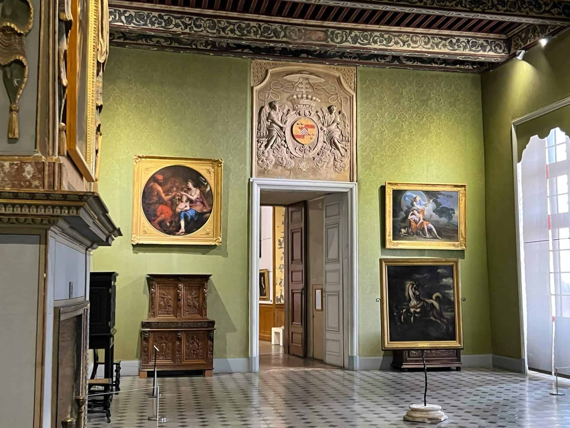 A room inside the Archbishop's Palace with green walls and paintings