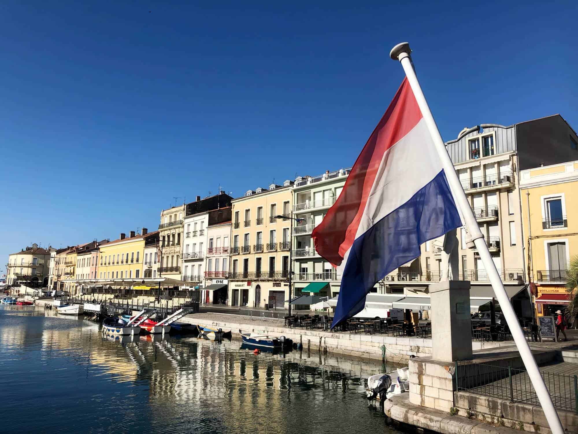 Houses by the canal and a French flag 
