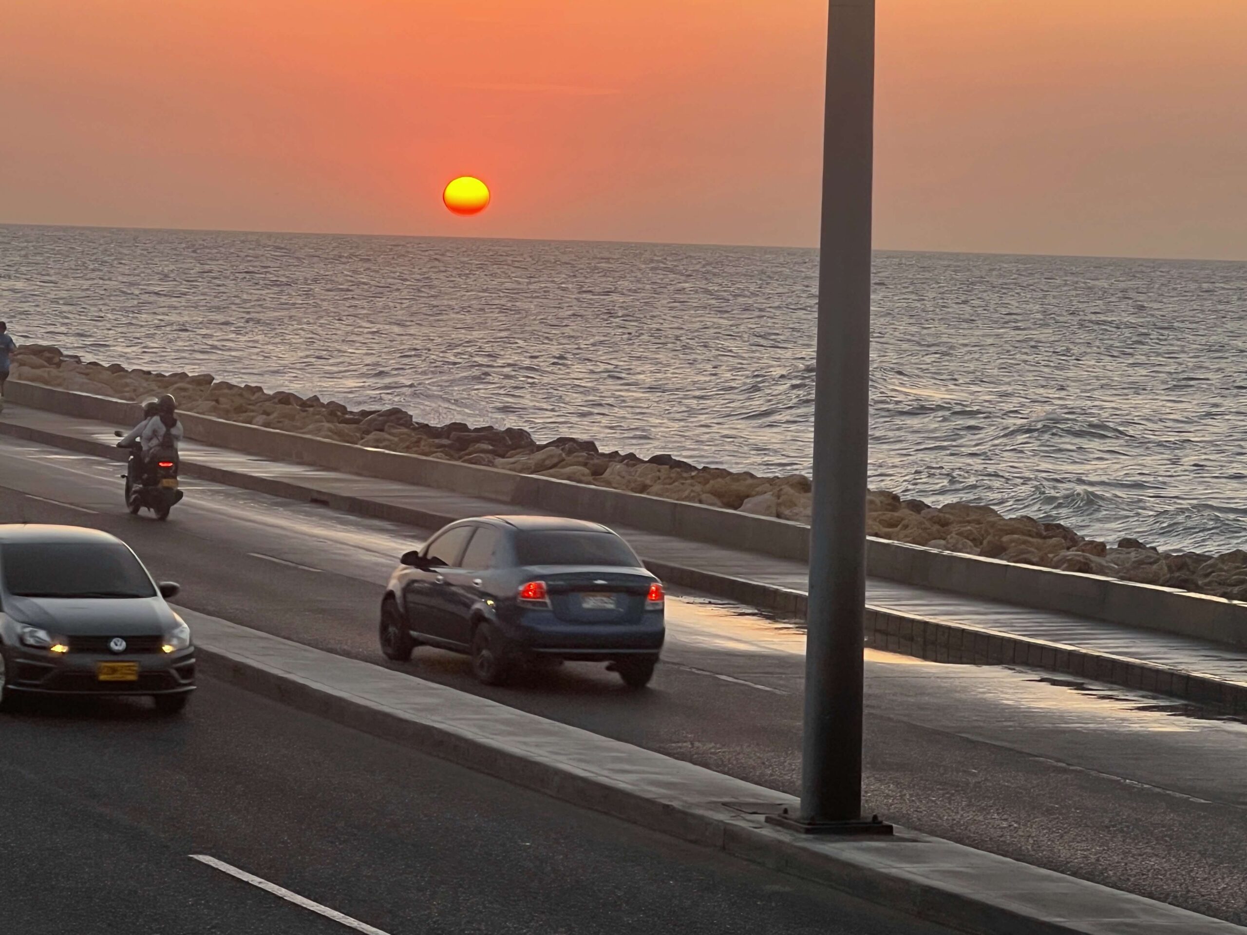 Sunset with 2 cars and a motorcycle